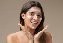 Femme souriante avec des touches de BB crème sur le visage