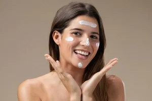 Femme souriante avec des touches de BB crème sur le visage