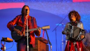 Un homme joue de la guitare, et une femme, de l'accordéon.