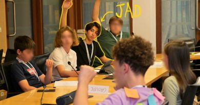 Photo d'ados à une table officielle du CESE avec micros intégrés. Certains lèvent la main pour prendre la parole. C'est le cas de Jad