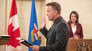 Peter Guthrie prête serment. Danielle Smith se trouve derrière lui.