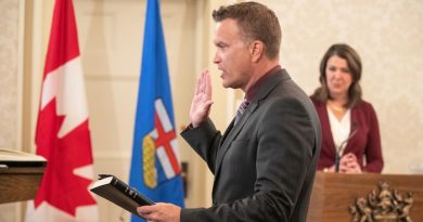 Peter Guthrie prête serment. Danielle Smith se trouve derrière lui.