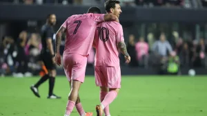 Deux joueurs de soccer en rose célèbrent un but.