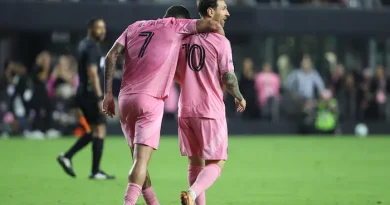 Deux joueurs de soccer en rose célèbrent un but.