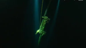 Les deux mâts en bois sont visibles dans la noirceur des eaux profondes.