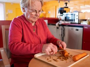 Une personne âgée épluchant des carottes