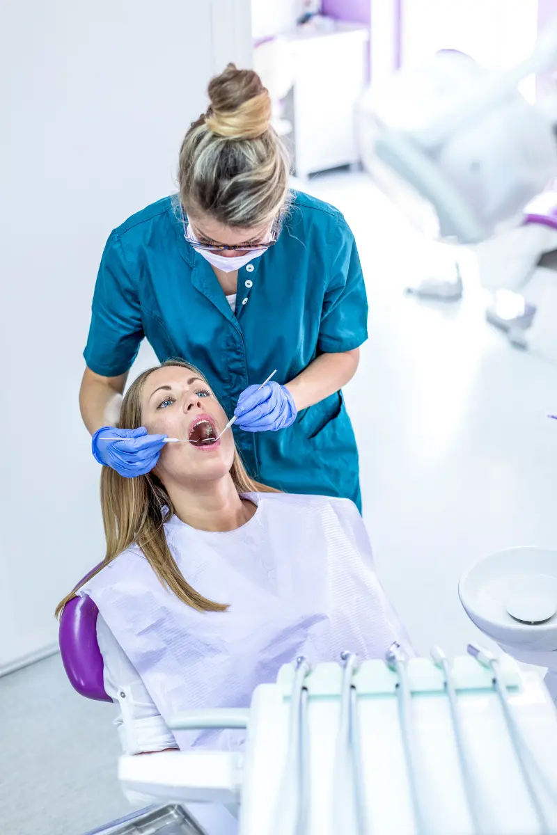 Dentiste examinant une patiente en cabinet soins dentaires en PACA