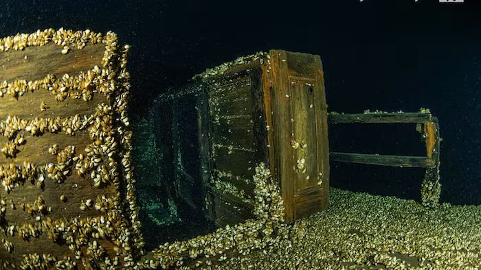 Des cabines et une rampe sur le point du bateau, recouvert de moules dans les profondeurs.