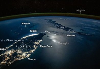 A photograph of the tip of Florida and nearby Cuba from space, with lights from cities illuminating the surface of the planet, labeled cities like Orlando and Tampa are seen as well as a green surface over Earth's labeled airglow