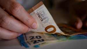 Des billets de banque tenus dans des mains
