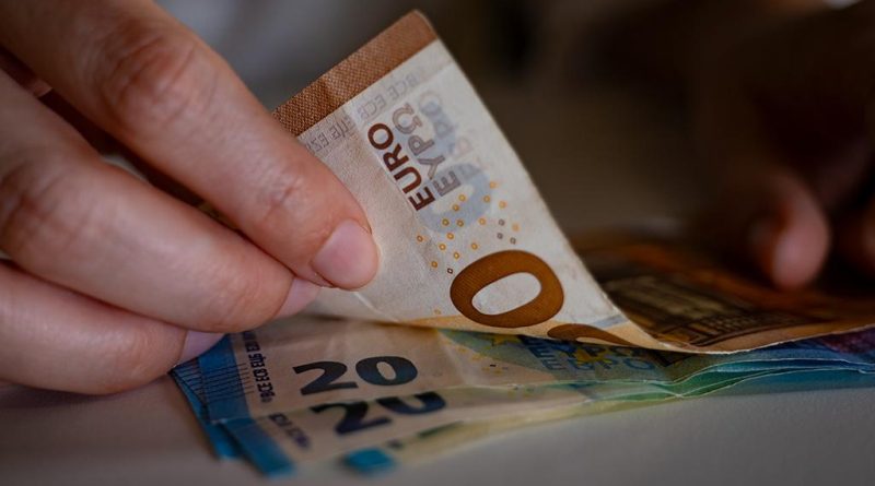 Des billets de banque tenus dans des mains