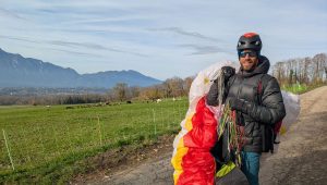 Guilhem vient d'atterrir et replie son parapente sur la route à Méry - ICI