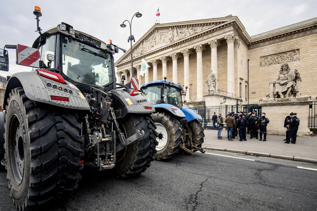 Photo montrant deux tracteurs stationnés devant l'Assemblée nationale à Paris.