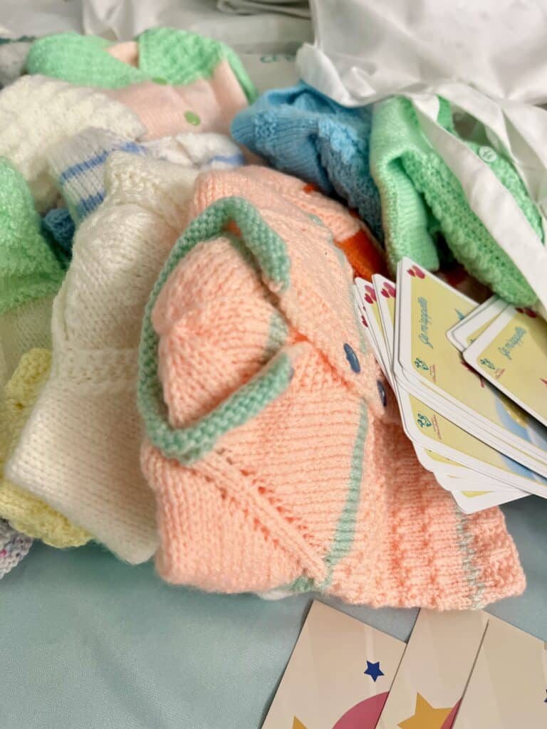 Les kits de naissance avec des jeux de cartes, des vêtements pour enfants de diverses couleurs.