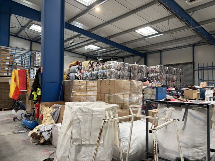 Les textiles, qui sont vendus dans les friperies partenaires, sont stockés soigneusement dans des cartons.