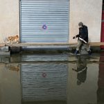 Un homme promène son chien dans une rue inondée d