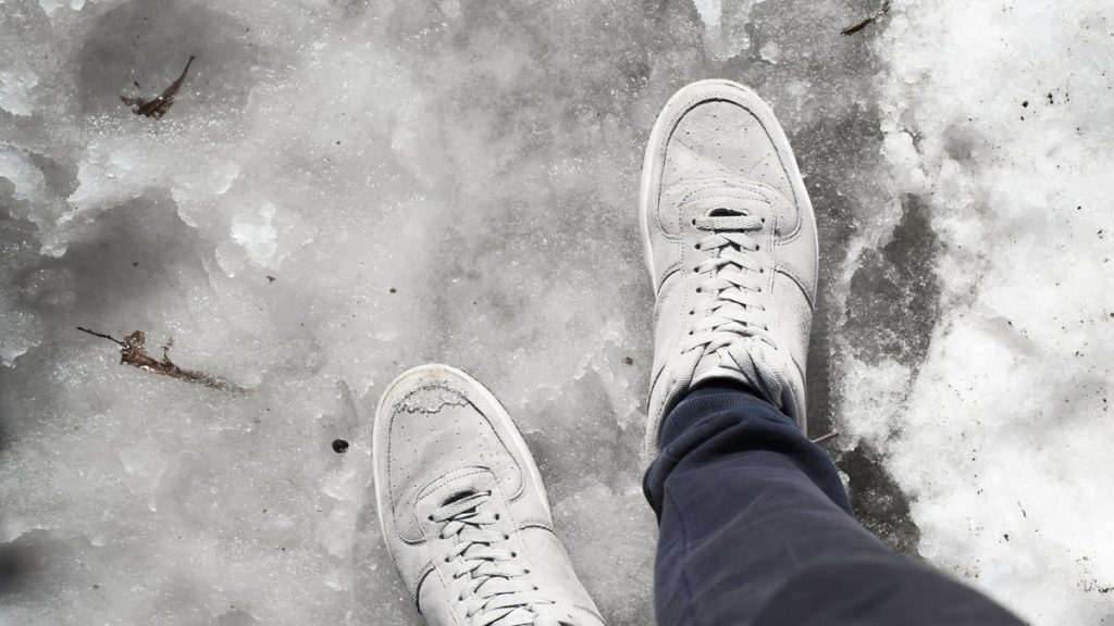 Deux jeunes randonneurs piégés dans une tempête de neige en montagne avec des baskets.