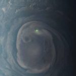 a bright dot of light in the center of a green and grey swirl