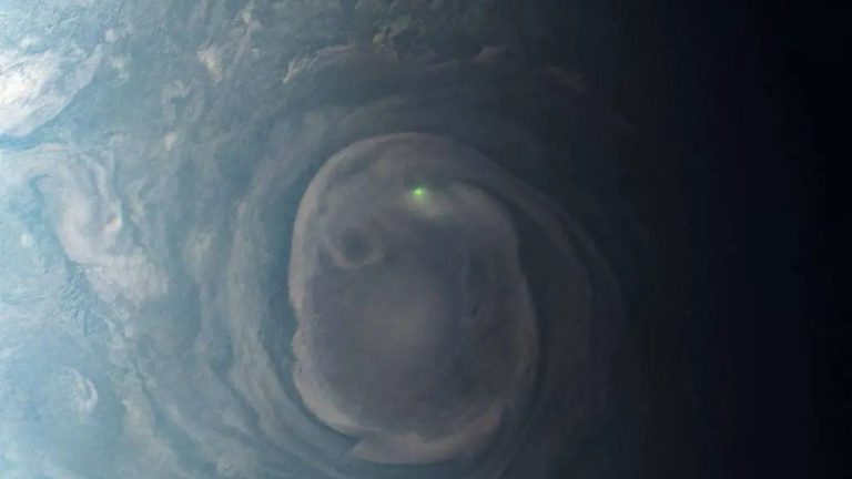 a bright dot of light in the center of a green and grey swirl