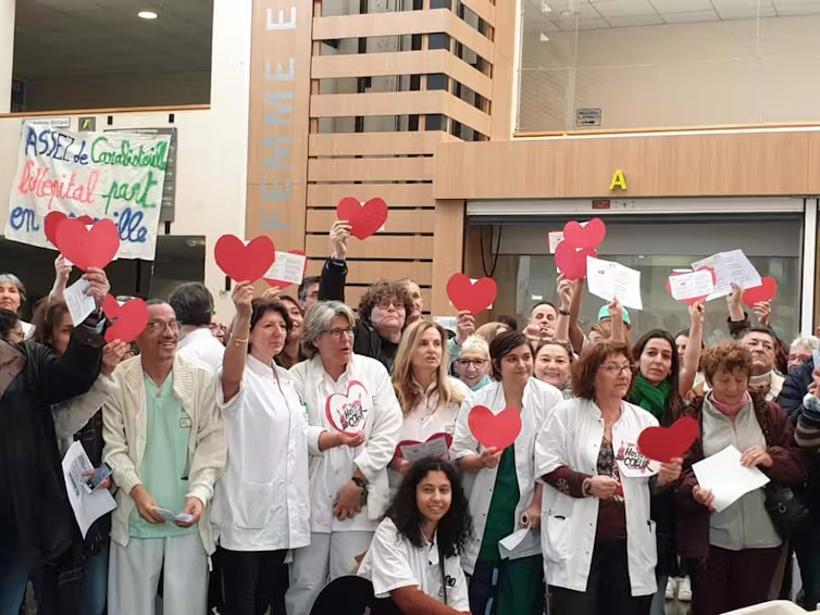 Manifestation de personnels soignants qui brandissent des cœurs roses