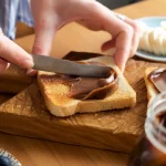 Spreading,Chocolate,Nut,Butter,On,Toasted,Bread.,Female,Hands,Smear