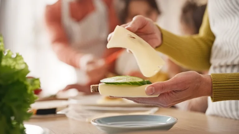Camera,View,Of,Woman,Holding,Sandwich,With,One,Hand.,Other