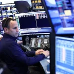 Des opérateurs de Wall Street dans le feu de l'action devant une foule d'écrans.