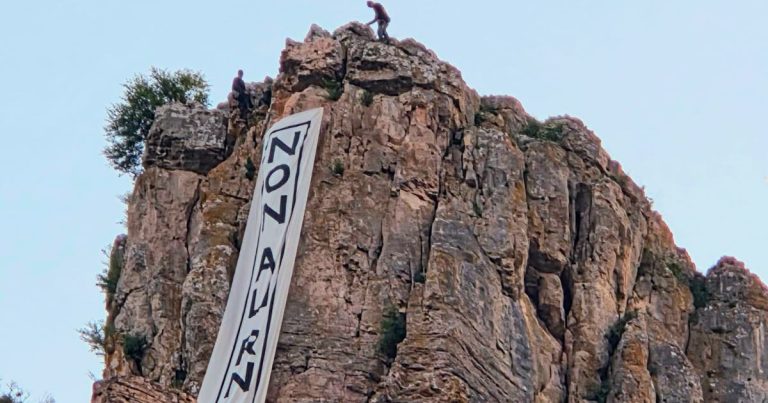 Des militants écologistes déploient une banderole « Non au RN » sur la Roche de Solutré.