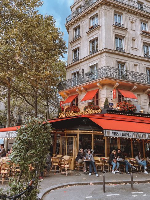 Quaint Parisian cafe with vibrant awnings, perfect for urban street photography.