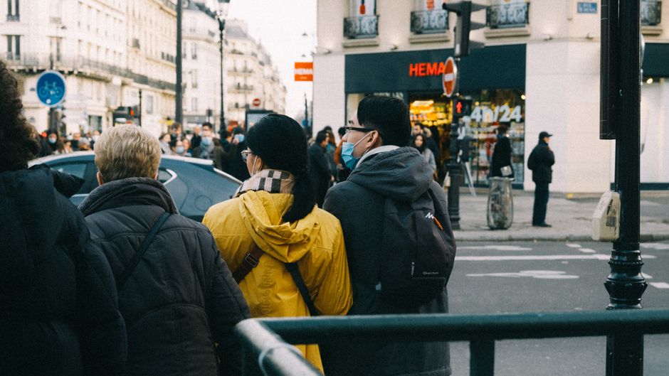 People walking on a busy street in winter, showcasing diverse interactions in an urban environment.