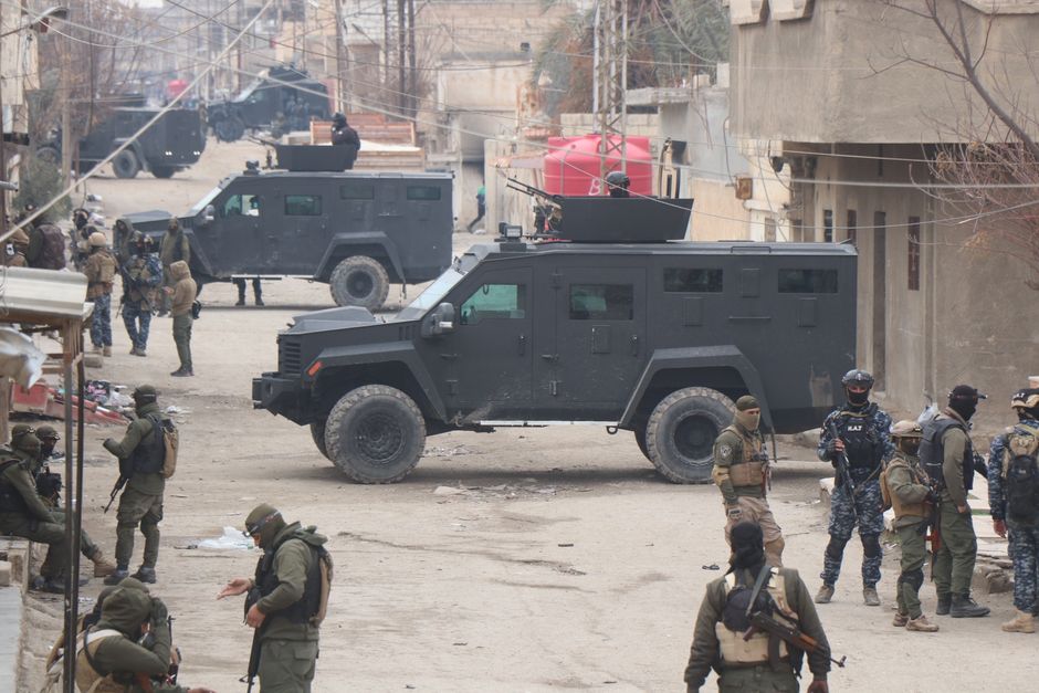 Armed forces in armored vehicles on the streets of Al Hasakah during a military operation.