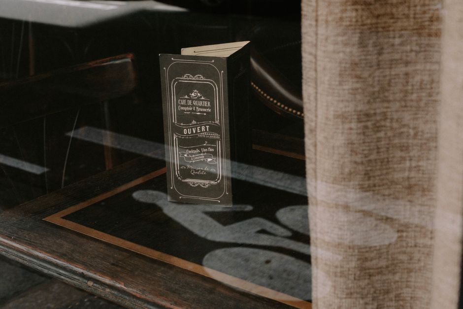 Reflection of a bicycle lane with café menu in window. Warm, inviting atmosphere.