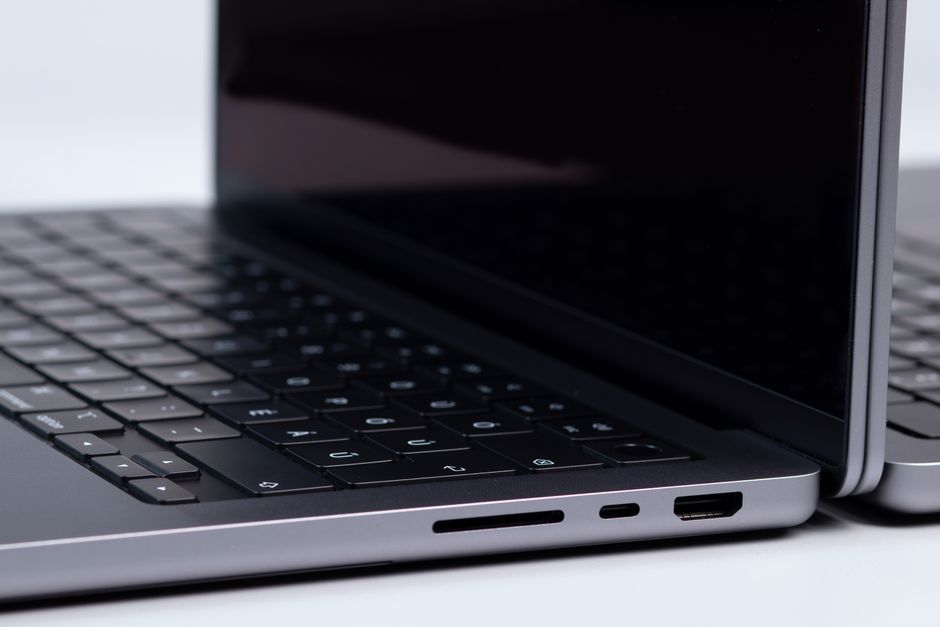 Detailed view of laptop ports and keyboards on a white surface, showcasing modern technology.