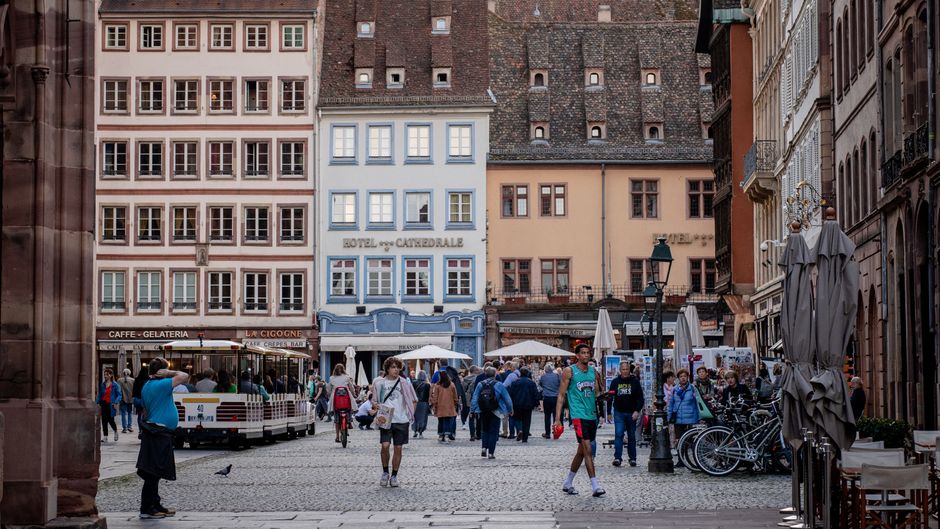 Charming street scene in Strasbourg with people walking in front of historic buildings.