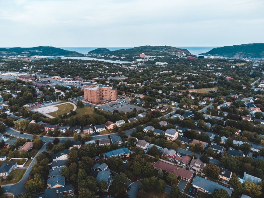 Stunning aerial view of a sprawling suburban neighborhood with greenery and distant mountains.