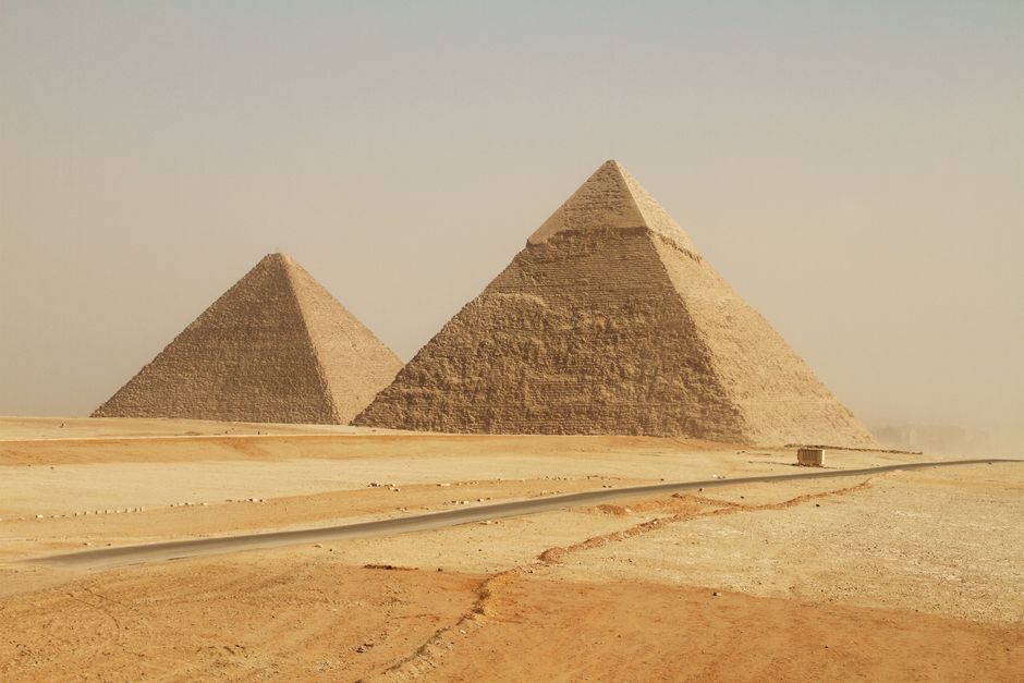 The iconic Giza Pyramids in Egypt stand tall in the desert landscape, showcasing ancient grandeur.