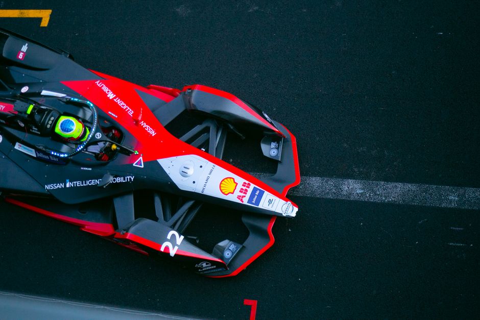 A dynamic top view of a Formula E car racing on a track in Ciudad de México.