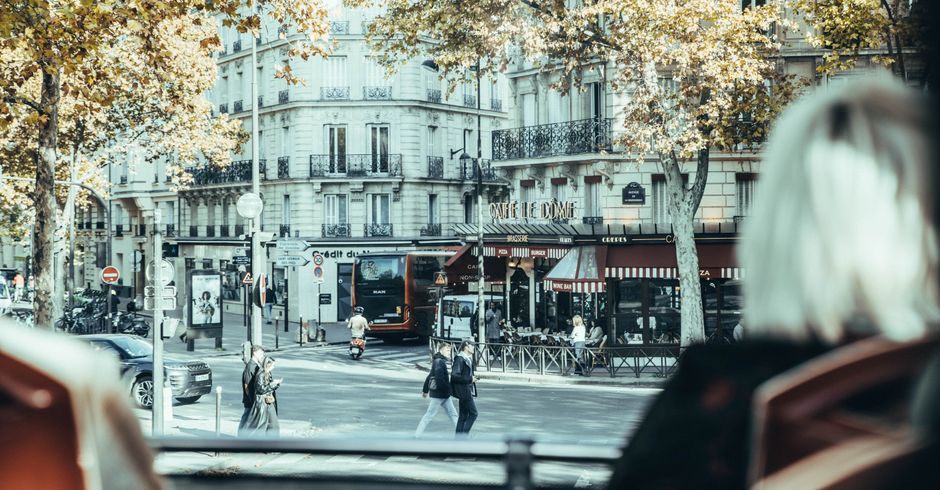 Quintessential Parisian street scene with autumn foliage and bustling city life.