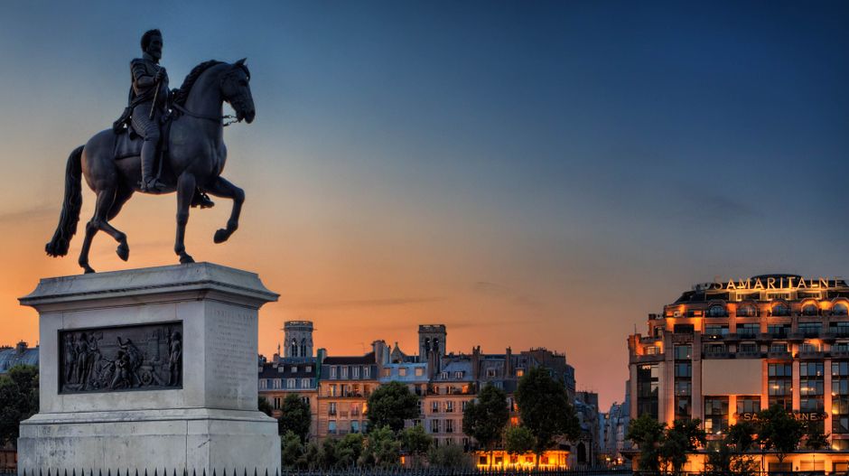 Equestrian statue in Paris at sunset, iconic cityscape view.