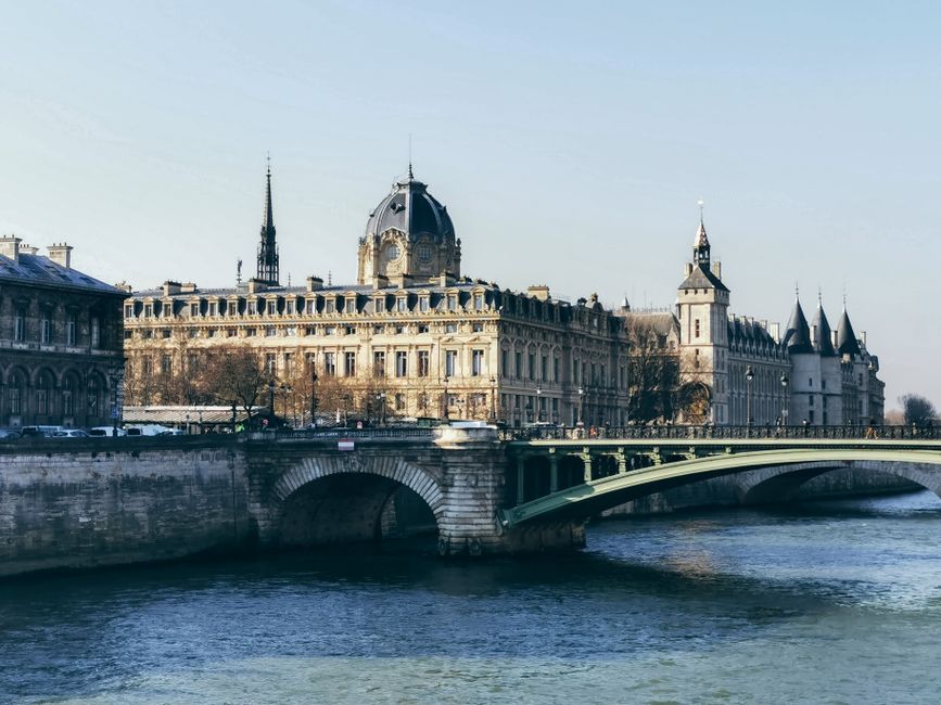 Beautiful view of iconic Parisian architecture and bridge over the Seine River, showcasing classic urban charm.