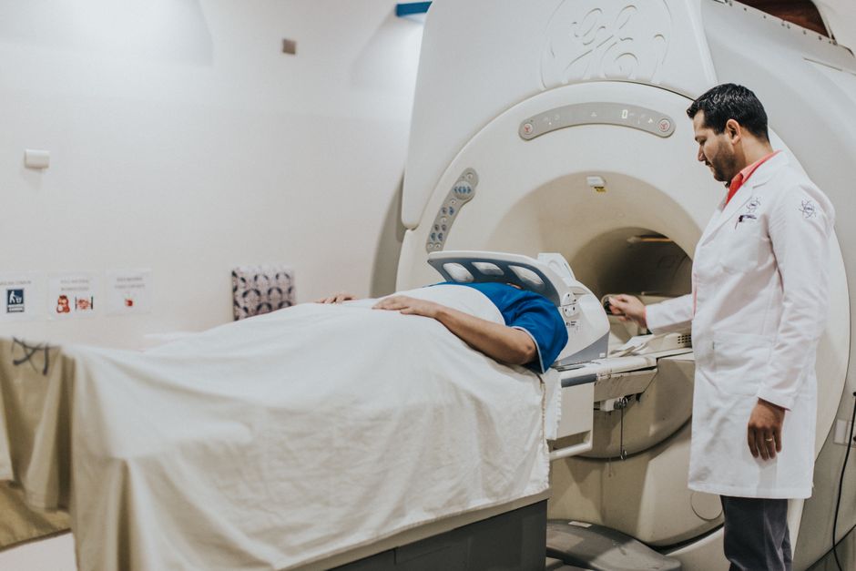 A doctor assists a patient during an MRI scan in a hospital setting, highlighting modern healthcare technology.