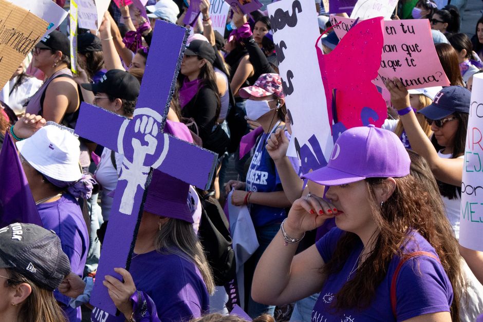 A vibrant women's rights protest in Mexico City with feminist symbols and placards.