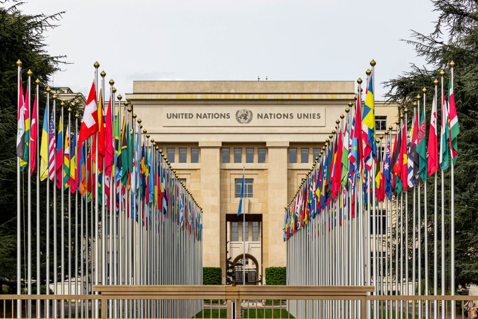 View of the United Nations Office in Geneva adorned with flags of various countries.