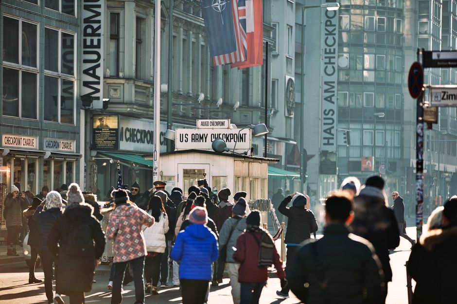 Crowd of tourists gathered at the historic Checkpoint Charlie in Berlin, Germany.