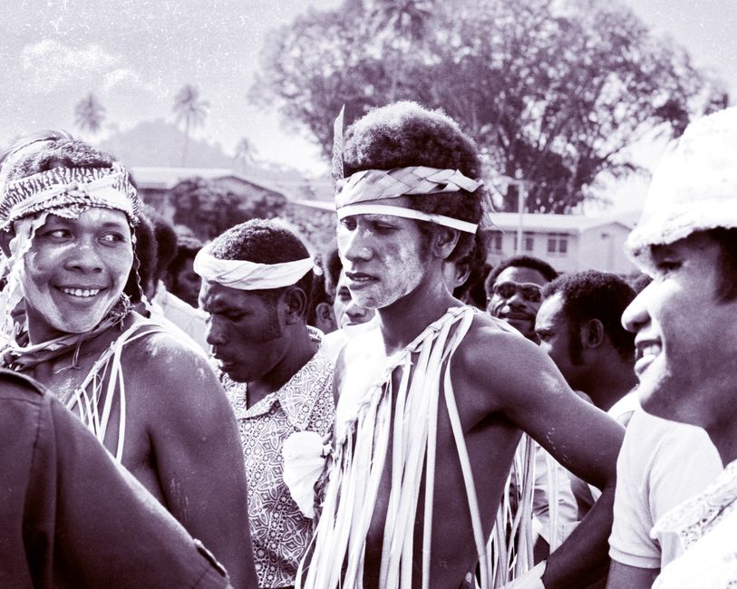 A group of indigenous people in traditional attire during an outdoor ceremony, exhibiting cultural heritage.