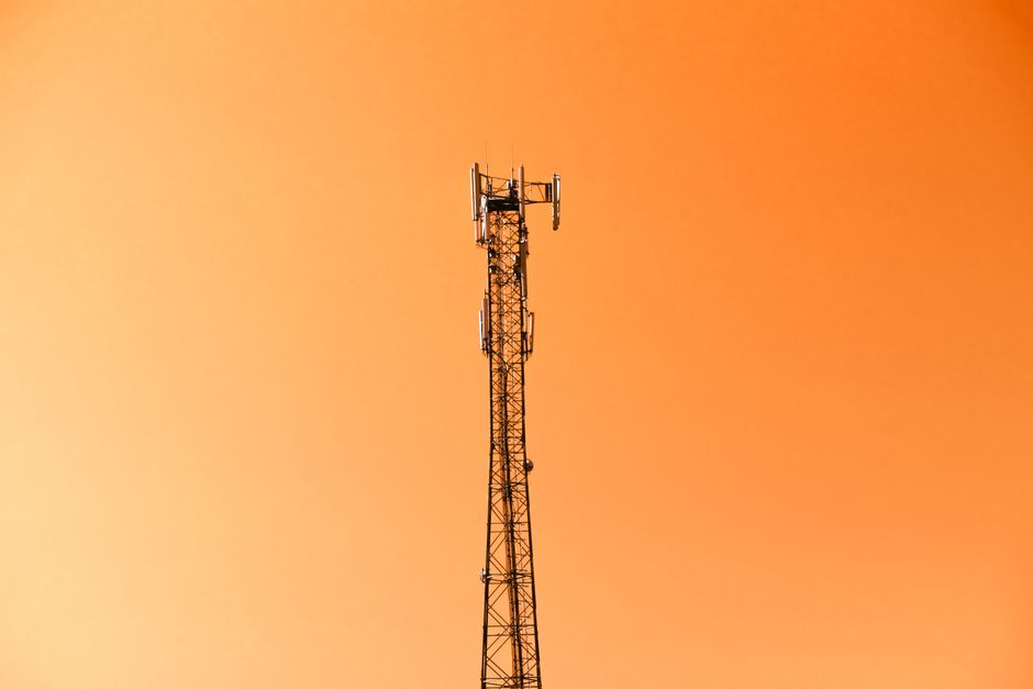 Radio mast silhouetted against a vibrant orange sky in Adana, Türkiye.
