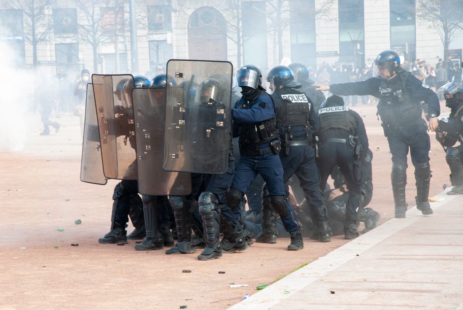 Police officers in riot gear control demonstration in Lyon city center.