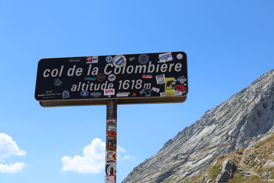 Road sign at Col de la Colombière, Le Reposoir, France, marked with stickers.