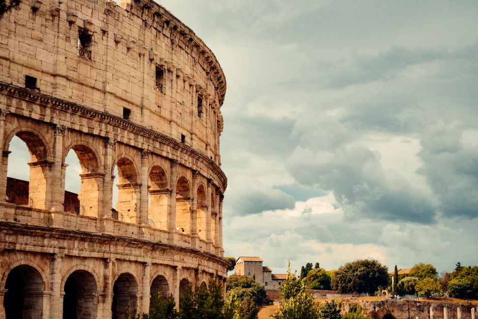 Stunning view of the iconic Colosseum in Rome under dramatic cloudy skies.