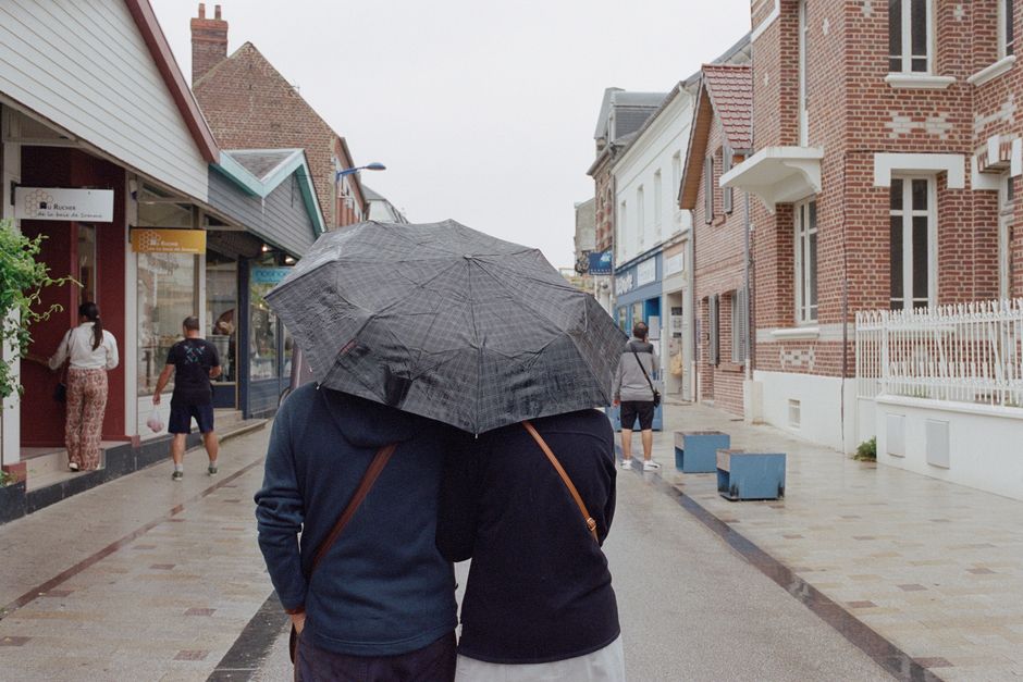 A couple walks arm in arm with an umbrella on a rainy day in Le Crotoy, Hauts-de-France.